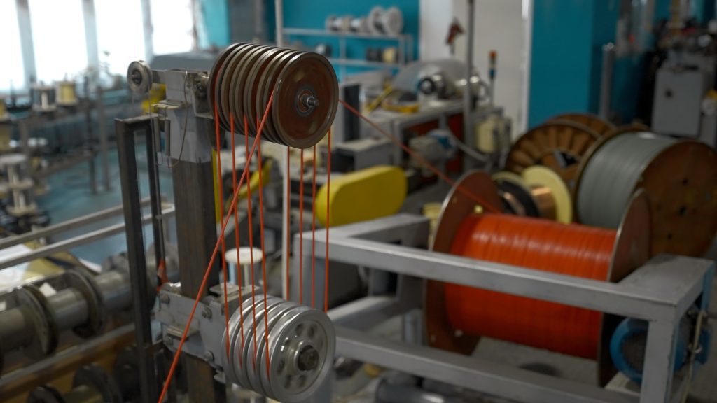 Steel wire coils at a tire factory. Creative. Rotating and reeling metal threads bobbins at modern